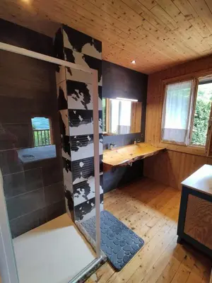 a room with a shower in a wooden house at Chalet Peppa in Sallanches