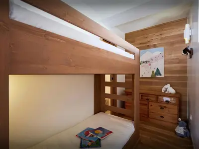 a bedroom with a bunk bed with a wooden wall at Chalet Jorat - OVO Network in Les Contamines-Montjoie
