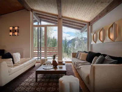 a living room with a couch and a large window at Chalet Jorat - OVO Network in Les Contamines-Montjoie