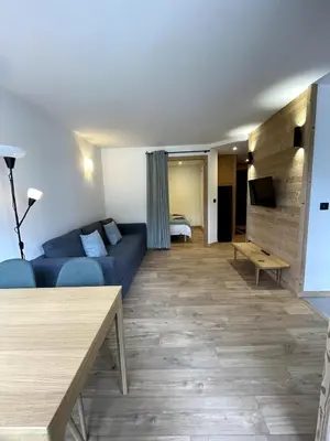 a living room with a blue couch and a bed at NEW Lac Chavants apartment - 4 beds in Les Houches
