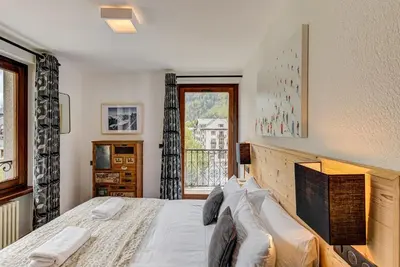 a bedroom with a large bed and a window at Apartment Winn, Alpes Travel, Central Chamonix, Sleeps 6 in Chamonix-Mont-Blanc