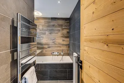 a bathroom with a bath tub and a sink at Apartment Winn, Alpes Travel, Central Chamonix, Sleeps 6 in Chamonix-Mont-Blanc