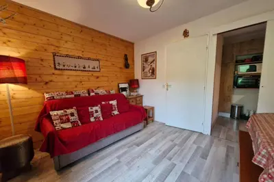 a living room with a red couch and wooden walls at Apartment with garden in Demi-Quartier in Demi-Quartier
