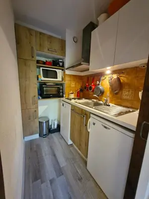 a kitchen with wooden floors and white cabinets at Apartment with garden in Demi-Quartier in Demi-Quartier