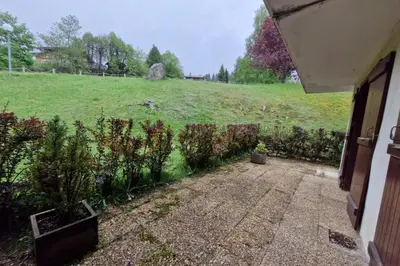 a yard with a field and a fence with plants at Apartment with garden in Demi-Quartier in Demi-Quartier