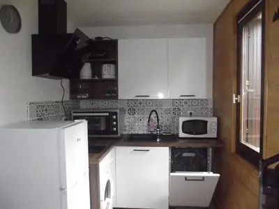 a kitchen with white cabinets and a white refrigerator at studio familial 4 couchages in Arâches-la-Frasse