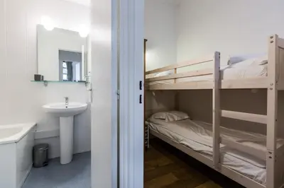 a bathroom with a bunk bed next to a sink and a mirror at Apartment Jonquille 3 - A Comfortable Chamonix Haven in Chamonix-Mont-Blanc