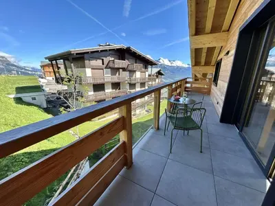 a balcony of a house with a table and chairs at Appartement 3 Pièces, 4-6 Couchages, Vue Montagne, Parking Privé - FR-1-597-192 in Combloux