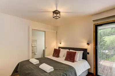 a bedroom with a large bed and a window at Mazot de Kayla, Alpes Travel, Les Houches, Sleeps 4 in Les Houches