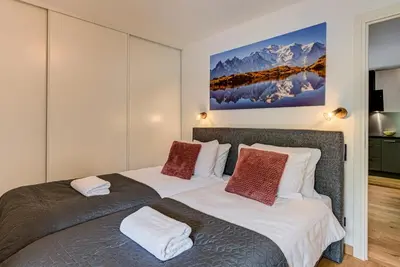 a bedroom with two beds and a painting on the wall at Mazot de Kayla, Alpes Travel, Les Houches, Sleeps 4 in Les Houches
