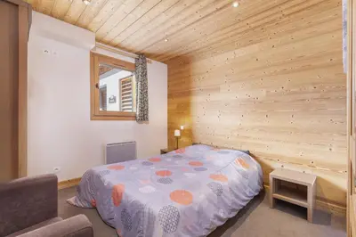 a bedroom with a bed in a wooden wall at Résidence Les Portes du Grand Massif - Flaine in Flaine