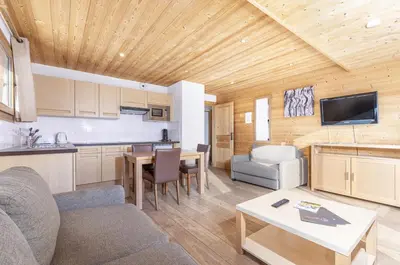 a living room with a couch and a table in a kitchen at Résidence Les Portes du Grand Massif - Flaine in Flaine