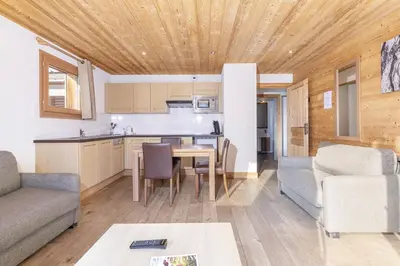 a kitchen and living room with a table and a couch at Résidence Les Portes du Grand Massif - Flaine in Flaine