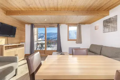 a living room with a wooden table and a couch at Résidence Les Portes du Grand Massif - Flaine in Flaine