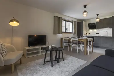 a living room with a couch and a table at Le mazot de Kayla - Espace bien être, picine in Les Houches
