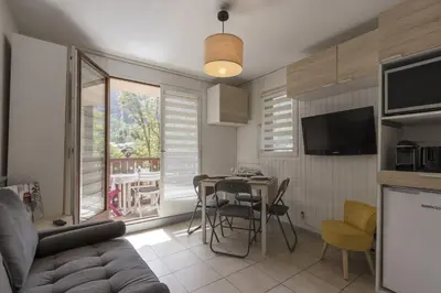 a living room with a couch and a table with chairs at Prarion Lac - Pied des pistes - Vue montagne in Les Houches