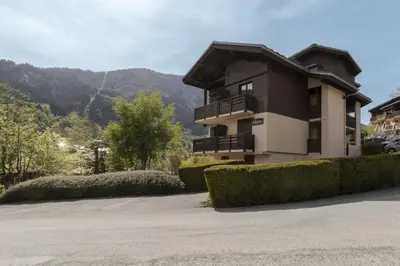 a building with a balcony with a mountain in the background at Prarion Lac - Pied des pistes - Vue montagne in Les Houches