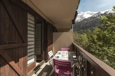 a table and chairs on a balcony with mountains at Prarion Lac - Pied des pistes - Vue montagne in Les Houches
