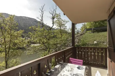 a balcony with a table and a view of a river at Prarion Lac - Pied des pistes - Vue montagne in Les Houches