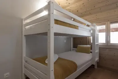 a bedroom with two bunk beds in a house at Trabets 2 - Vue Montagne - 150m des Remontees in Les Houches