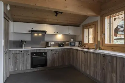 a kitchen with wooden cabinets and a counter top at Trabets 2 - Vue Montagne - 150m des Remontees in Les Houches