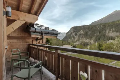 a balcony with a chair and a view of the mountains at Trabets 2 - Vue Montagne - 150m des Remontees in Les Houches