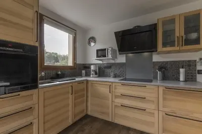 a kitchen with wooden cabinets and a window at Tout Schuss - Centre St Gervais - Vue degagee in Saint-Gervais-les-Bains