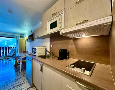 a kitchen with a sink and a microwave at appartement 4 personnes au coeur de la station des carroz d arâches in Arâches-la-Frasse