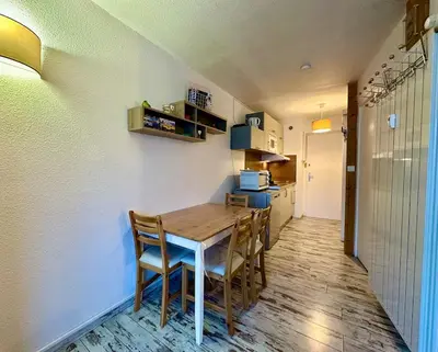 a kitchen and dining room with a table and chairs at appartement 4 personnes au coeur de la station des carroz d arâches in Arâches-la-Frasse