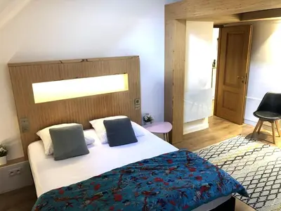 a bedroom with a white bed with a blue blanket at Duplex avec vue Mont-Blanc, centre ville Chamonix in Chamonix-Mont-Blanc