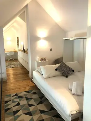 a bedroom with a bed with white sheets and pillows at Duplex avec vue Mont-Blanc, centre ville Chamonix in Chamonix-Mont-Blanc