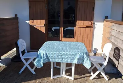a table and chairs sitting on a deck with a table and chairs at Cocon cozy, vue magique in Demi-Quartier