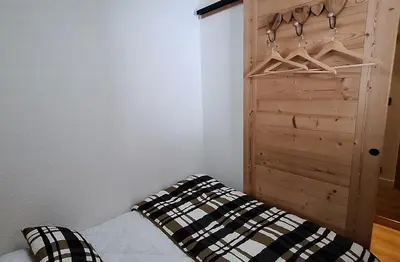 a bedroom with a bed and a wooden closet at Cocon cozy, vue magique in Demi-Quartier