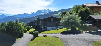 a house on a hill with mountains in the background at Cocon cozy, vue magique in Demi-Quartier