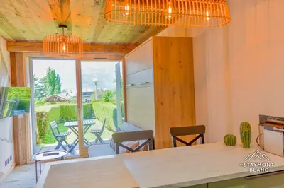 a room with a table and chairs and a large window at Nid douillet au pied du Tramway du MontBlanc à Saint-Gervais in Saint-Gervais-les-Bains