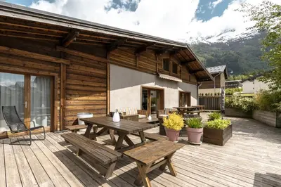 a wooden deck with a wooden table and benches at Chalet Zen - Sauna Hammam - Vue Mont-Blanc in Chamonix-Mont-Blanc