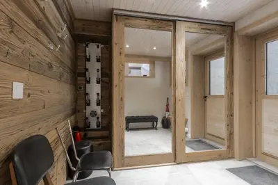 a room with wooden walls and a door with chairs at Chalet Zen - Sauna Hammam - Vue Mont-Blanc in Chamonix-Mont-Blanc