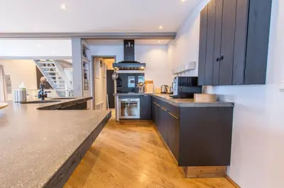 a kitchen with blue cabinets and a counter top at Chalet Zen - Sauna Hammam - Vue Mont-Blanc in Chamonix-Mont-Blanc