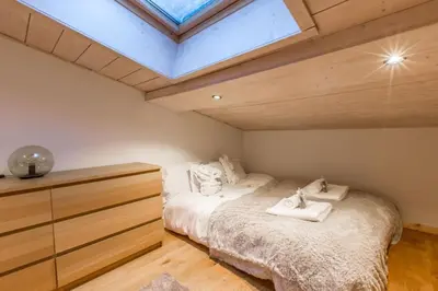 a bedroom with a bed and a skylight at Chalet Zen - Sauna Hammam - Vue Mont-Blanc in Chamonix-Mont-Blanc