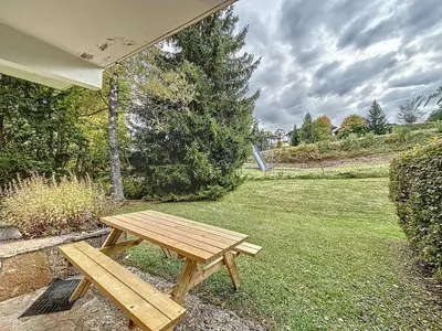 a wooden picnic table sitting in the grass at Appartement 2 pièces au pied des pistes à Combloux - FR-1-560-162 in Combloux