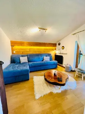 a living room with a blue couch and a table at Elegant et cosy, Appt à la montagne in Combloux