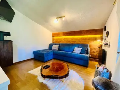 a living room with a blue couch and a table at Elegant et cosy, Appt à la montagne in Combloux