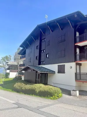 an apartment building with a black roof on a street at Elegant et cosy, Appt à la montagne in Combloux