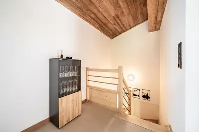 a tasting room with a black refrigerator and wooden ceilings at Apartment Cerna Les Houches - by EMERALD STAY in Les Houches