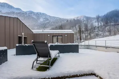 a chair sitting on top of a snow covered yard at Apartment Cerna Les Houches - by EMERALD STAY in Les Houches