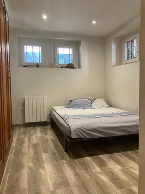a bedroom with a bed and two windows at Rare, charmant T3 de 63m2, calme dans une maison, place de parking comprise in Chamonix-Mont-Blanc
