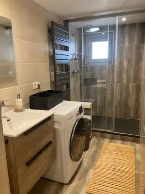 a bathroom with a washing machine and a shower at Rare, charmant T3 de 63m2, calme dans une maison, place de parking comprise in Chamonix-Mont-Blanc