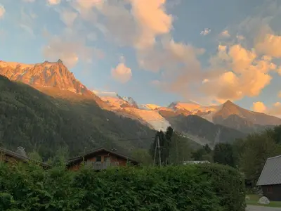 a view of a mountain range with trees and a house at Rare, charmant T3 de 63m2, calme dans une maison, place de parking comprise in Chamonix-Mont-Blanc