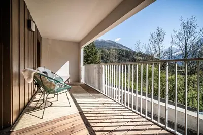 a dining room with a table and chairs on a balcony at Apartment Omas Les Houches - by EMERALD STAY in Les Houches