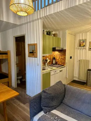 a living room with a couch and a kitchen at Les Airelles 402 in Arâches-la-Frasse